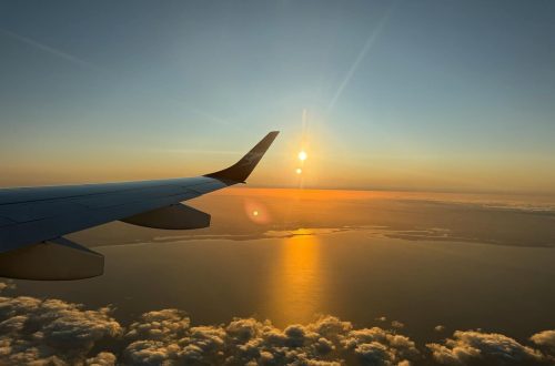 Capture of a mesmerizing ocean sunset viewed from an airplane window during flight.