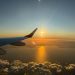 Capture of a mesmerizing ocean sunset viewed from an airplane window during flight.