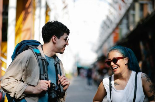 Smiling man and woman enjoying a conversation outdoors, capturing a candid moment.